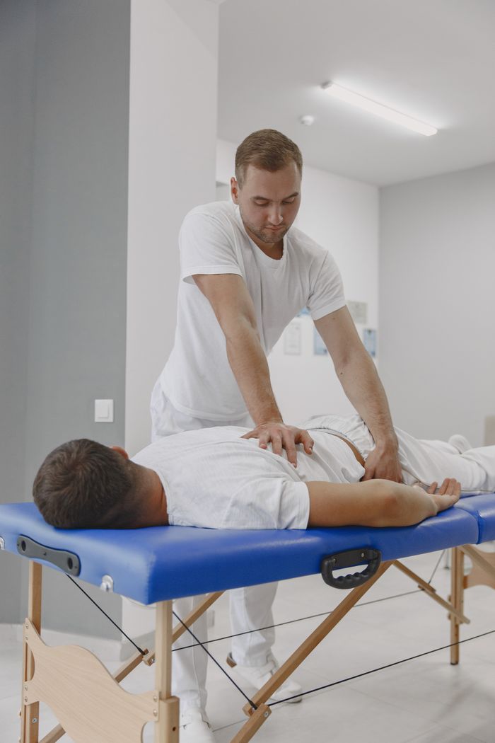 Services Chiropractor conducting a therapy session for back pain relief in a massage room.